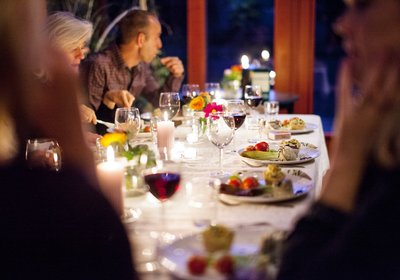 Folk rundt bordet med mat og vin